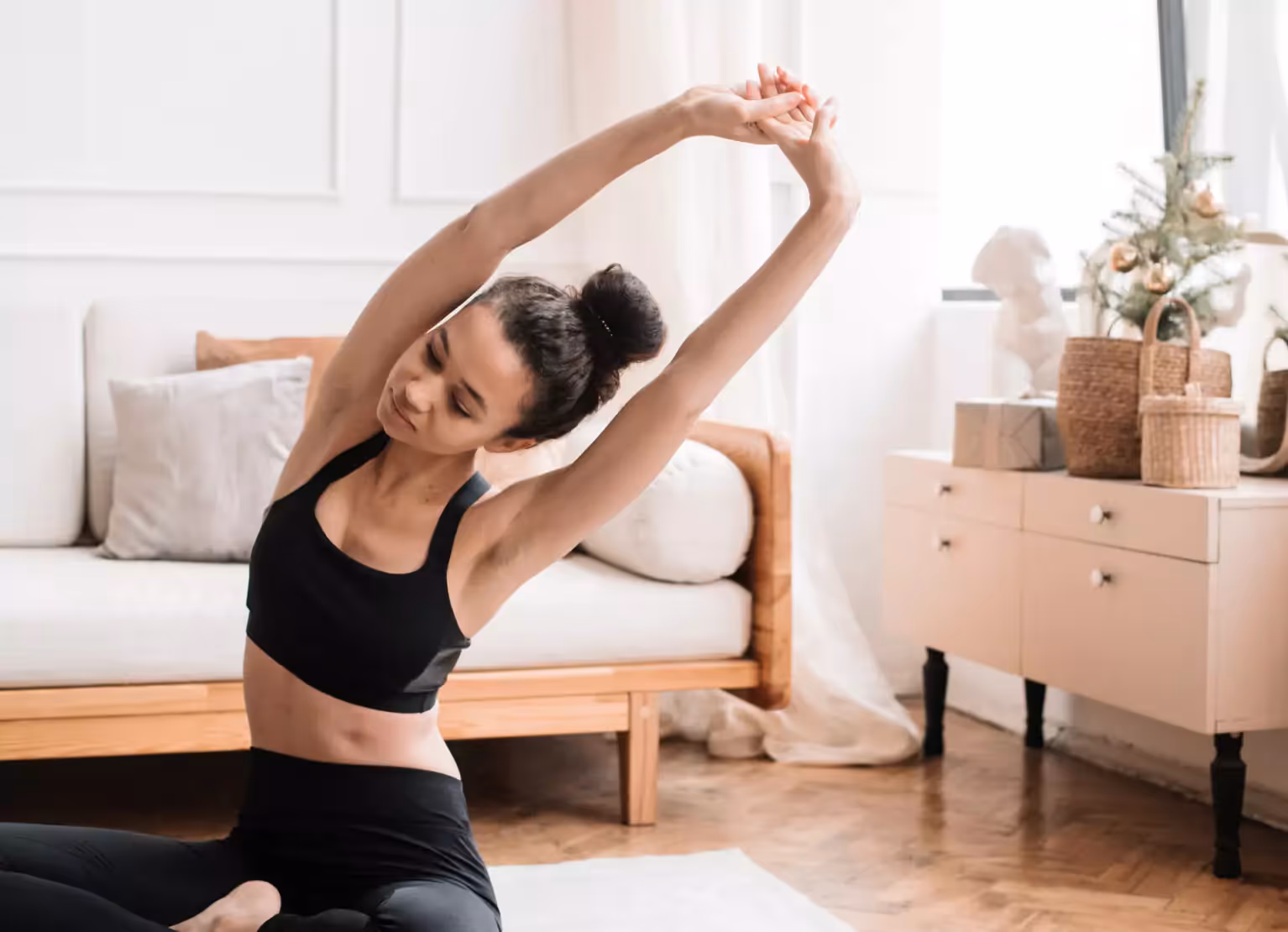 Person wearing workout gear and stretching at home