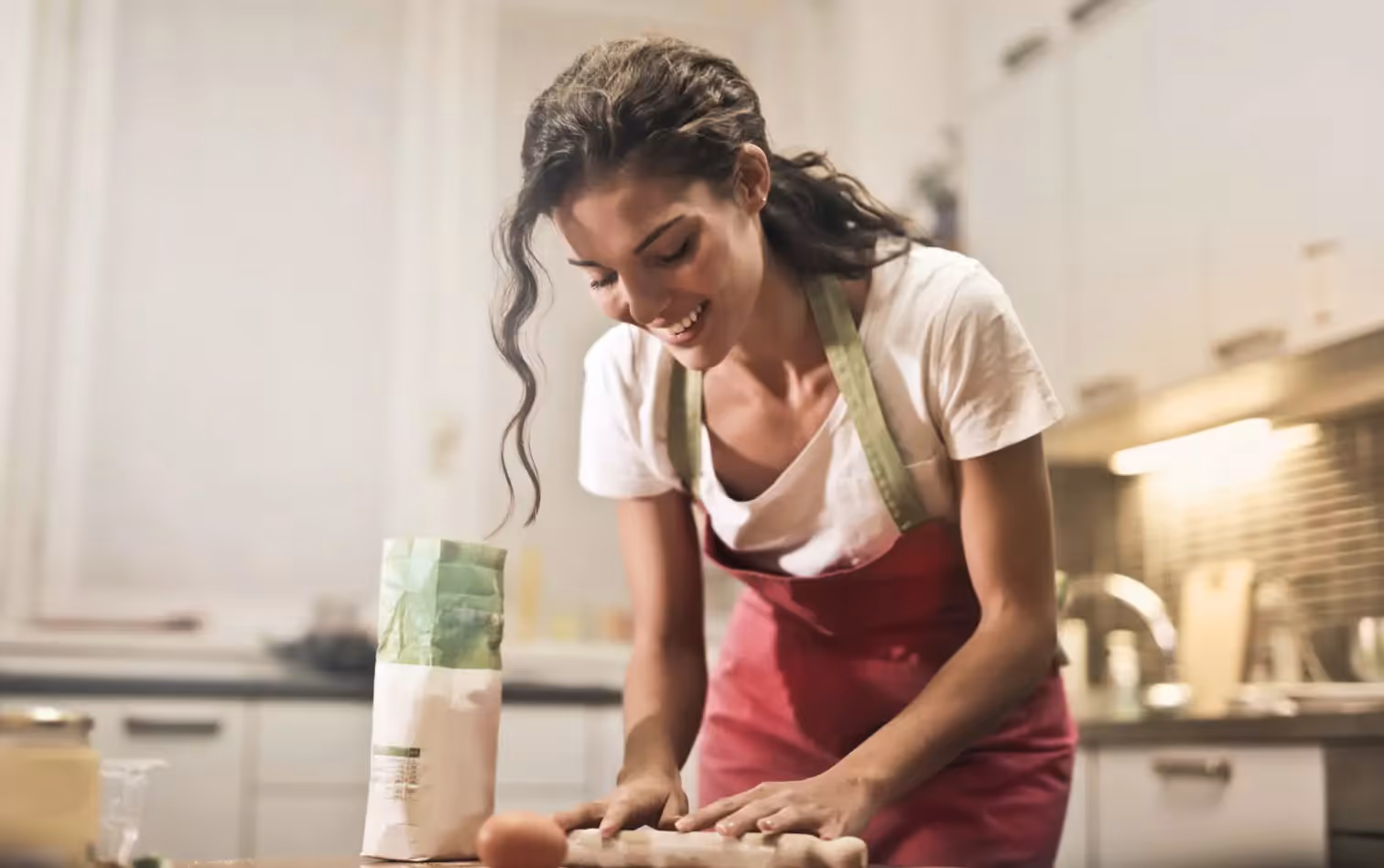 A woman laughing as she bakes