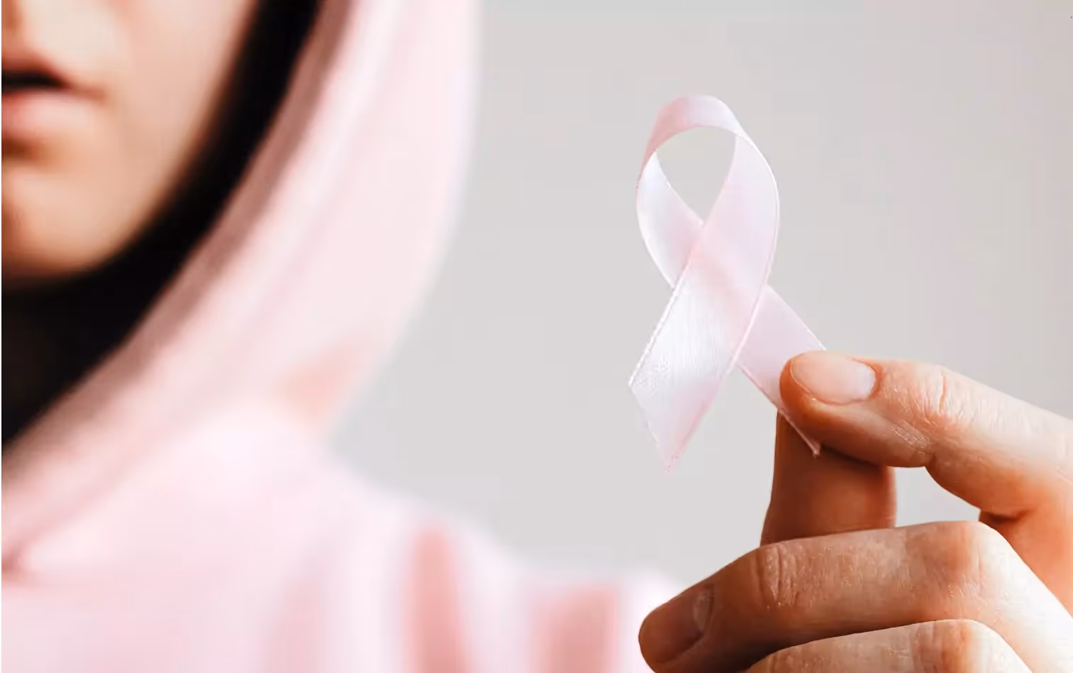 a person holding a pink ribbon