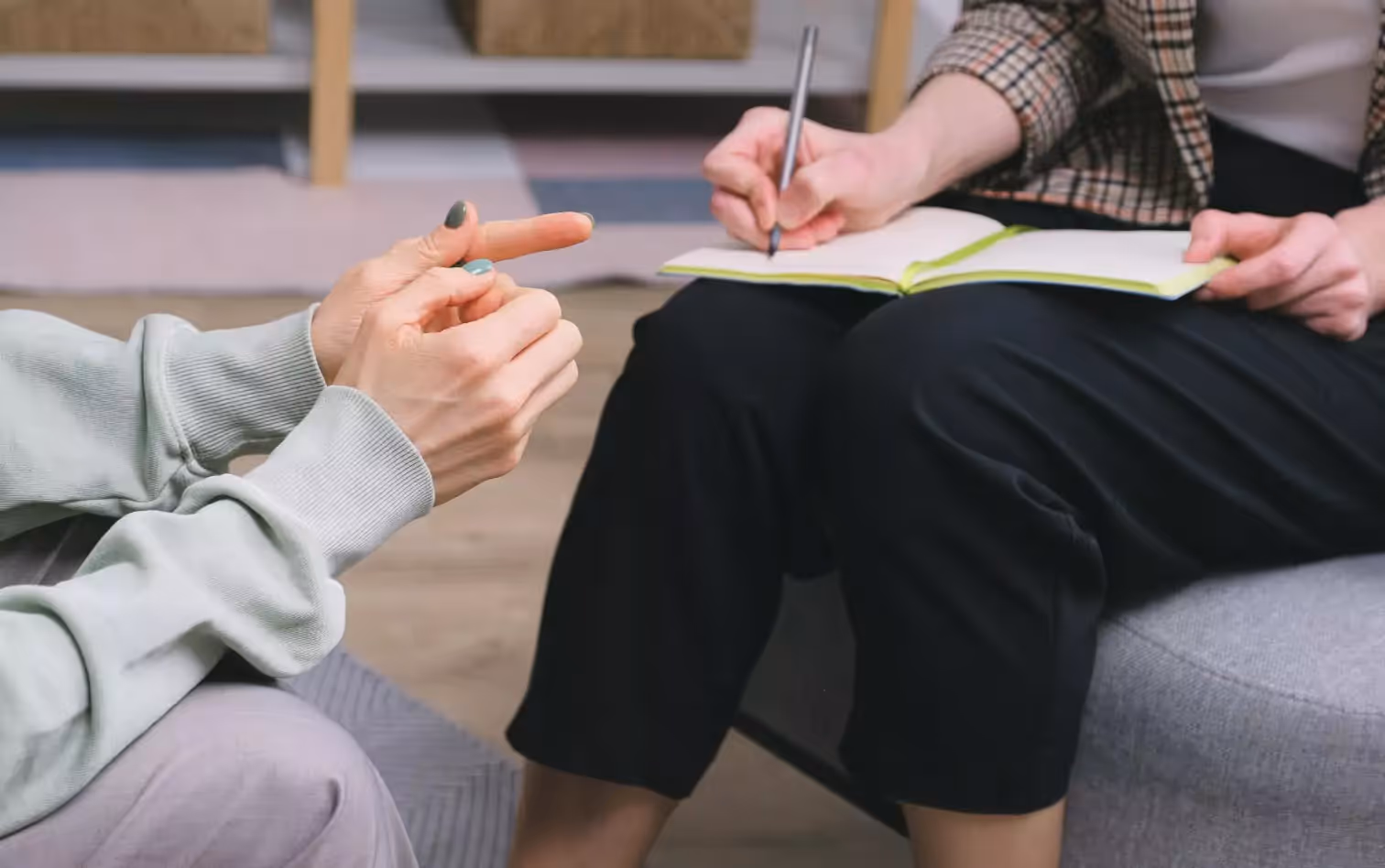 two people talking, one of them making notes 