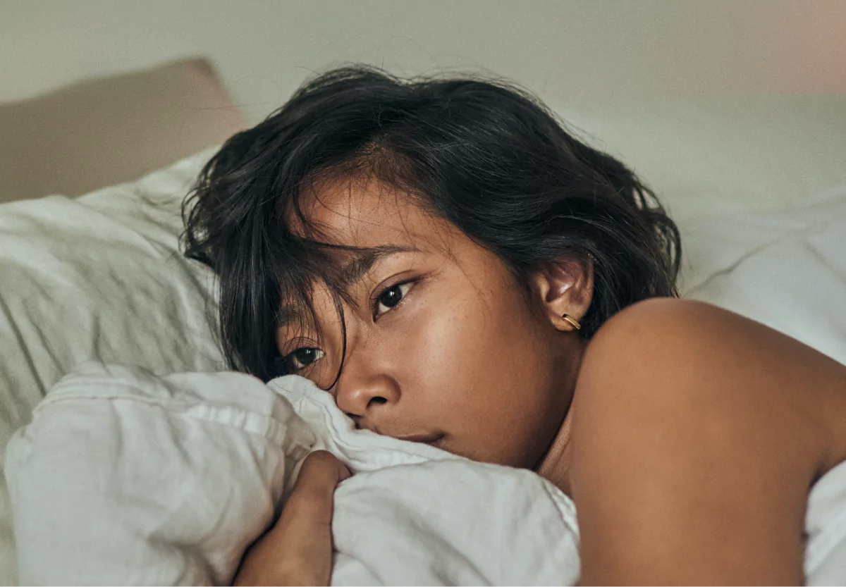 a girl looking distressed in bed