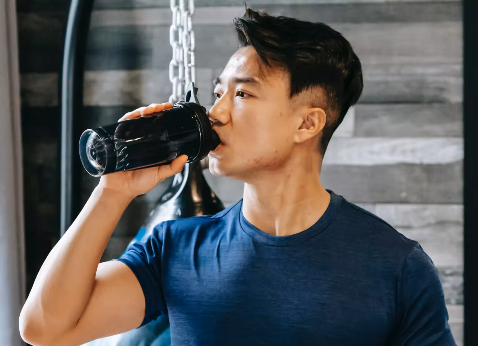a person drinking pre-workout at gym
