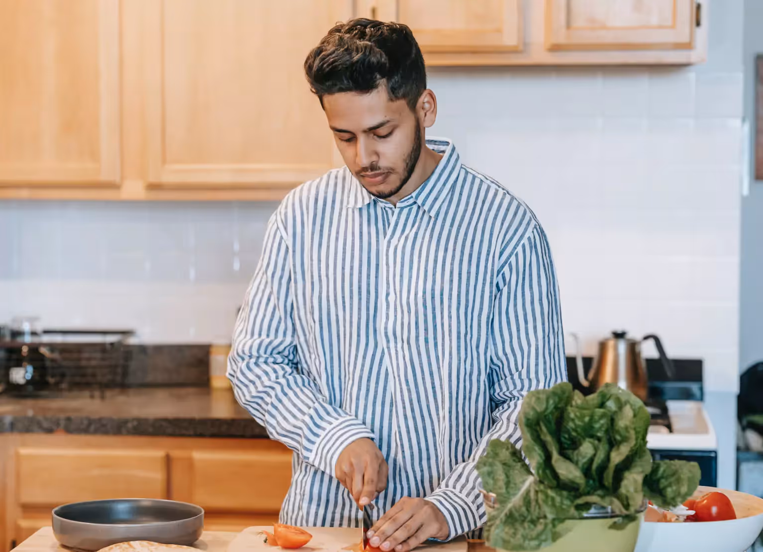 a person chopping vegetables in kitchen