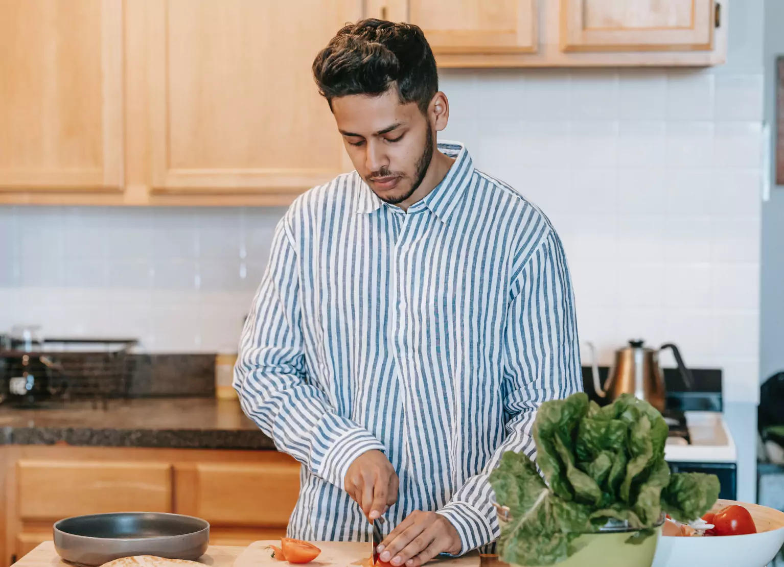 a person chopping vegetables in kitchen