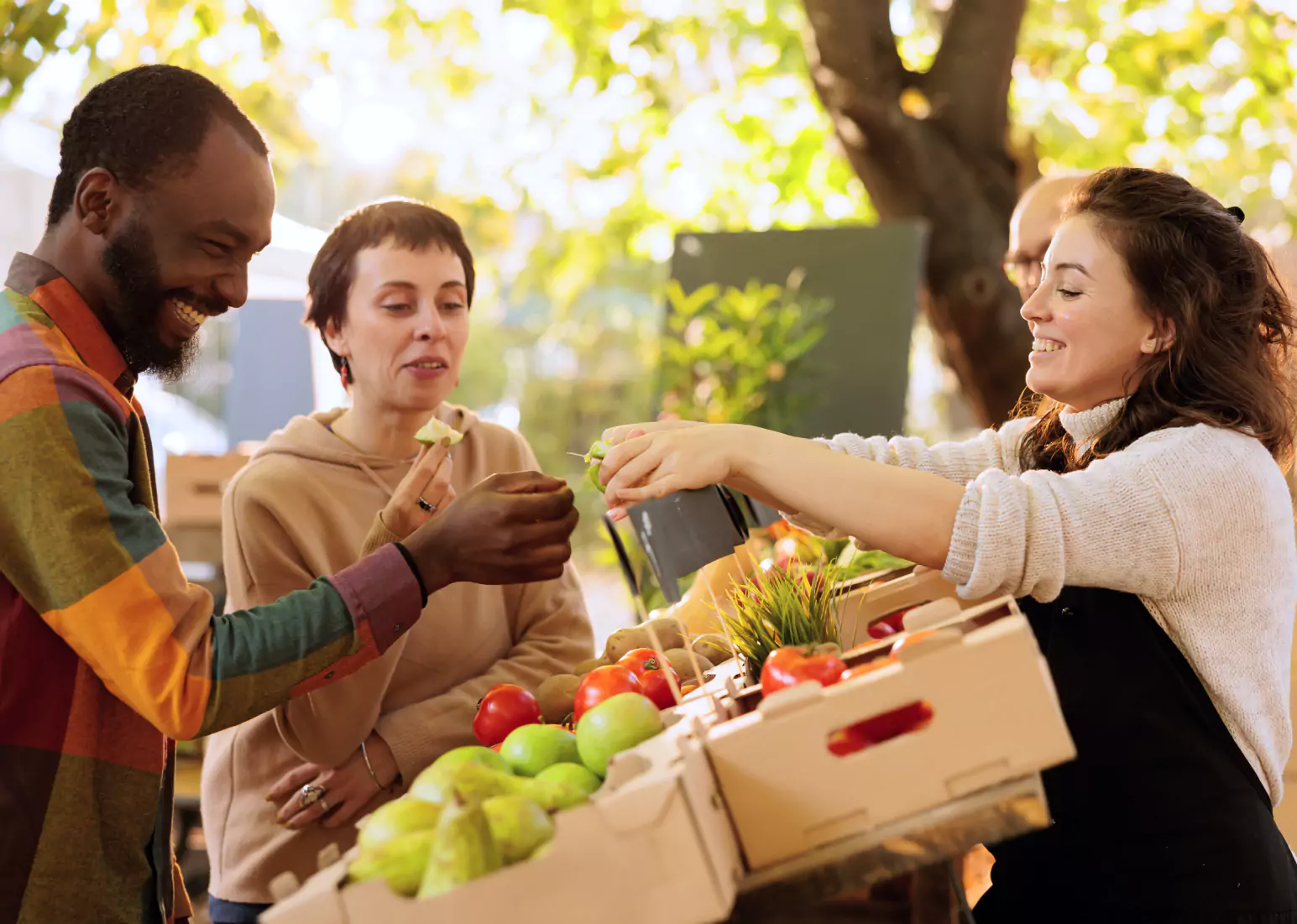 A group of people shopping outdoors for fresh produce 