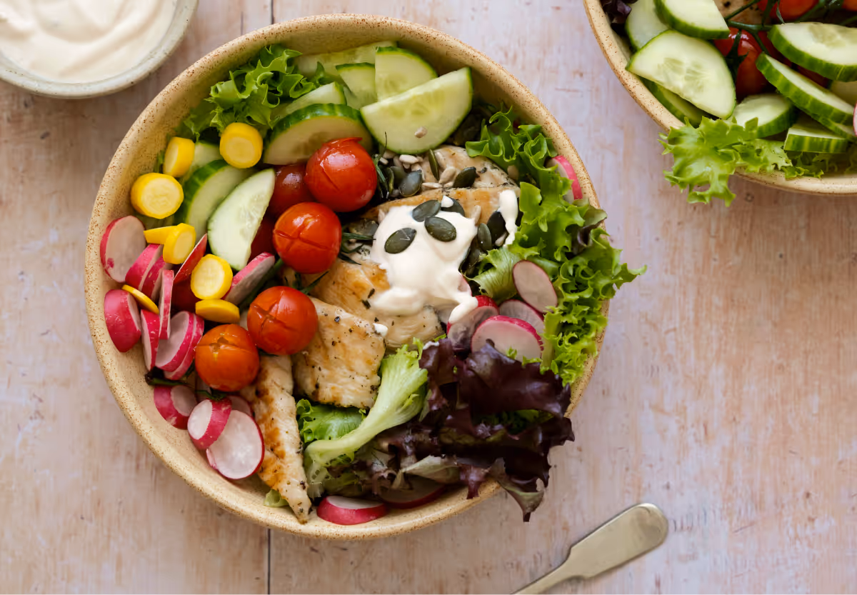 A colourful salad in a bowl on a wood grain table