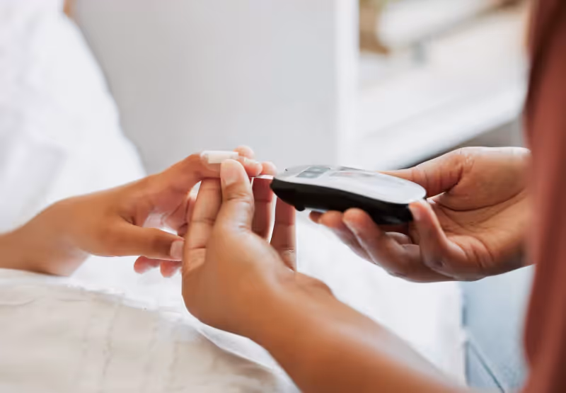 someone getting their blood sugar read with a glucometer