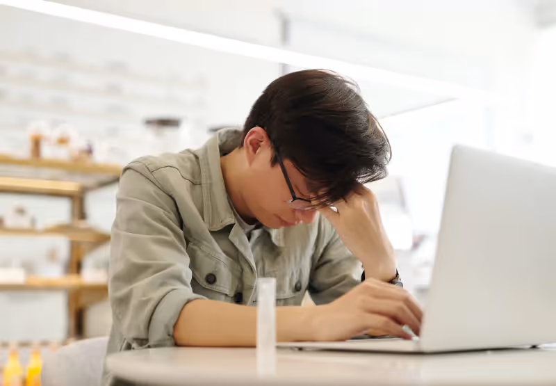 a man experiencing a headache while using a computer