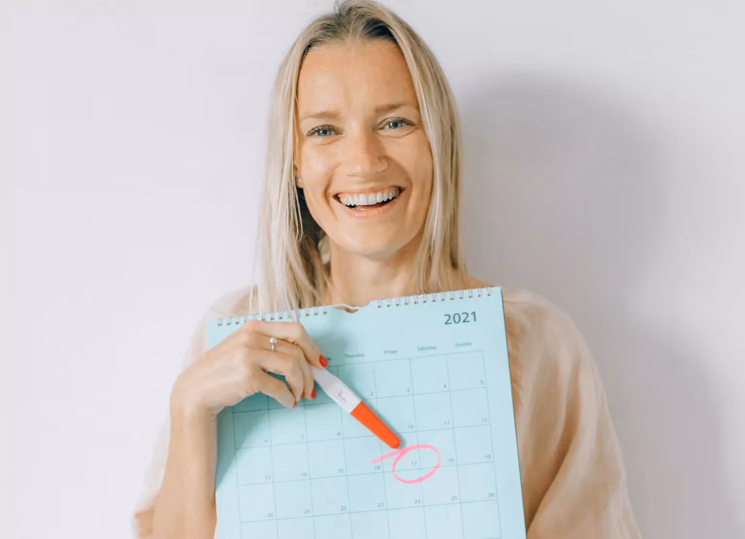 a woman showing a calendar with a cycled date 