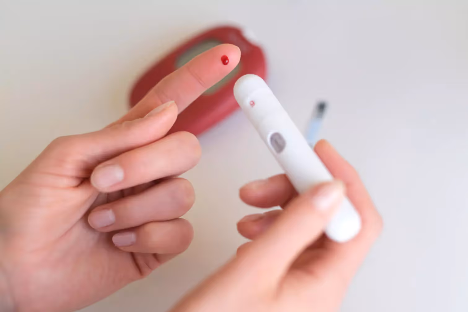 a person using finger prick method to test their glucose level