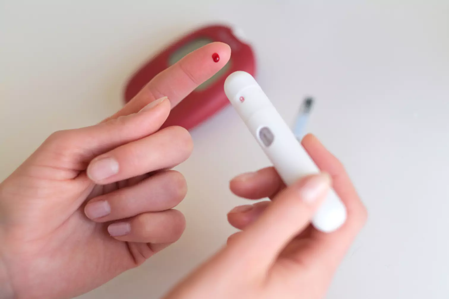 a person using finger prick method to test their glucose level