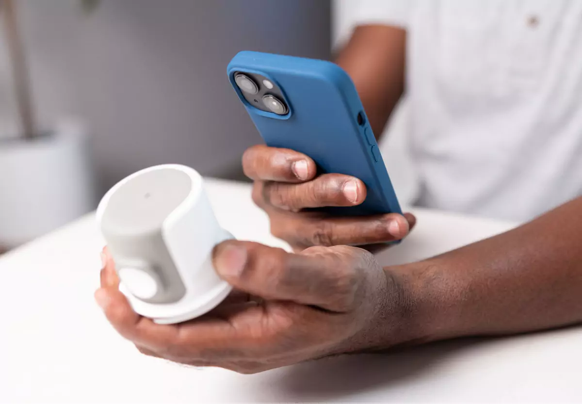 someone holding a CGM and a mobile phone