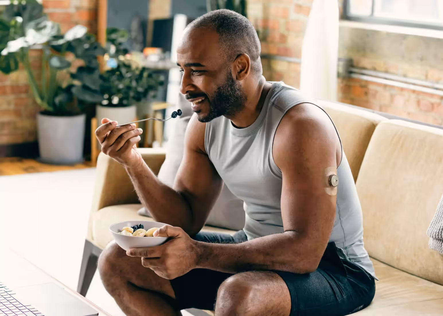 Someone sitting outdoors scanning a continuous glucose monitor with a smartphone
