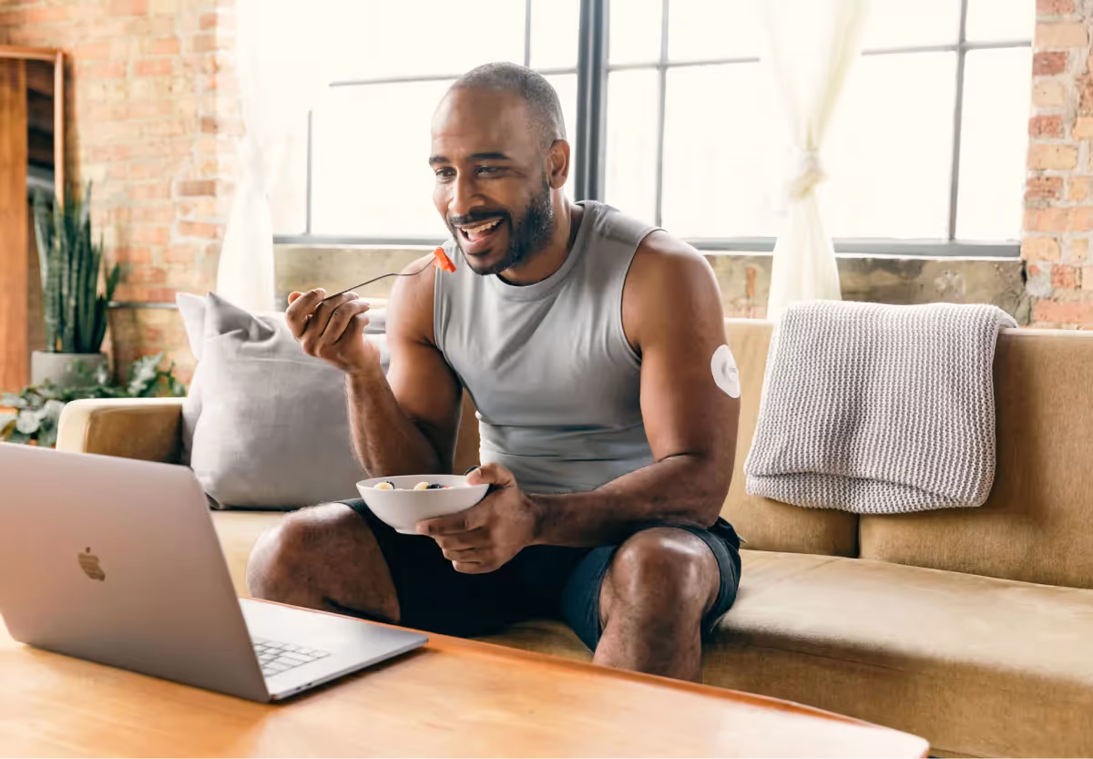 a man with a cgm patch eating a salad
