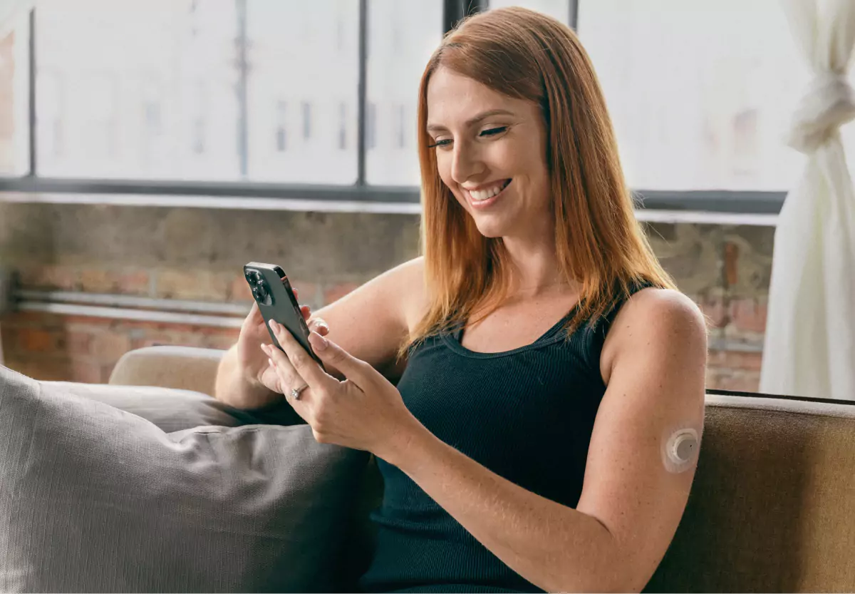 a person wearing CGM and looking at a glucose monitor 