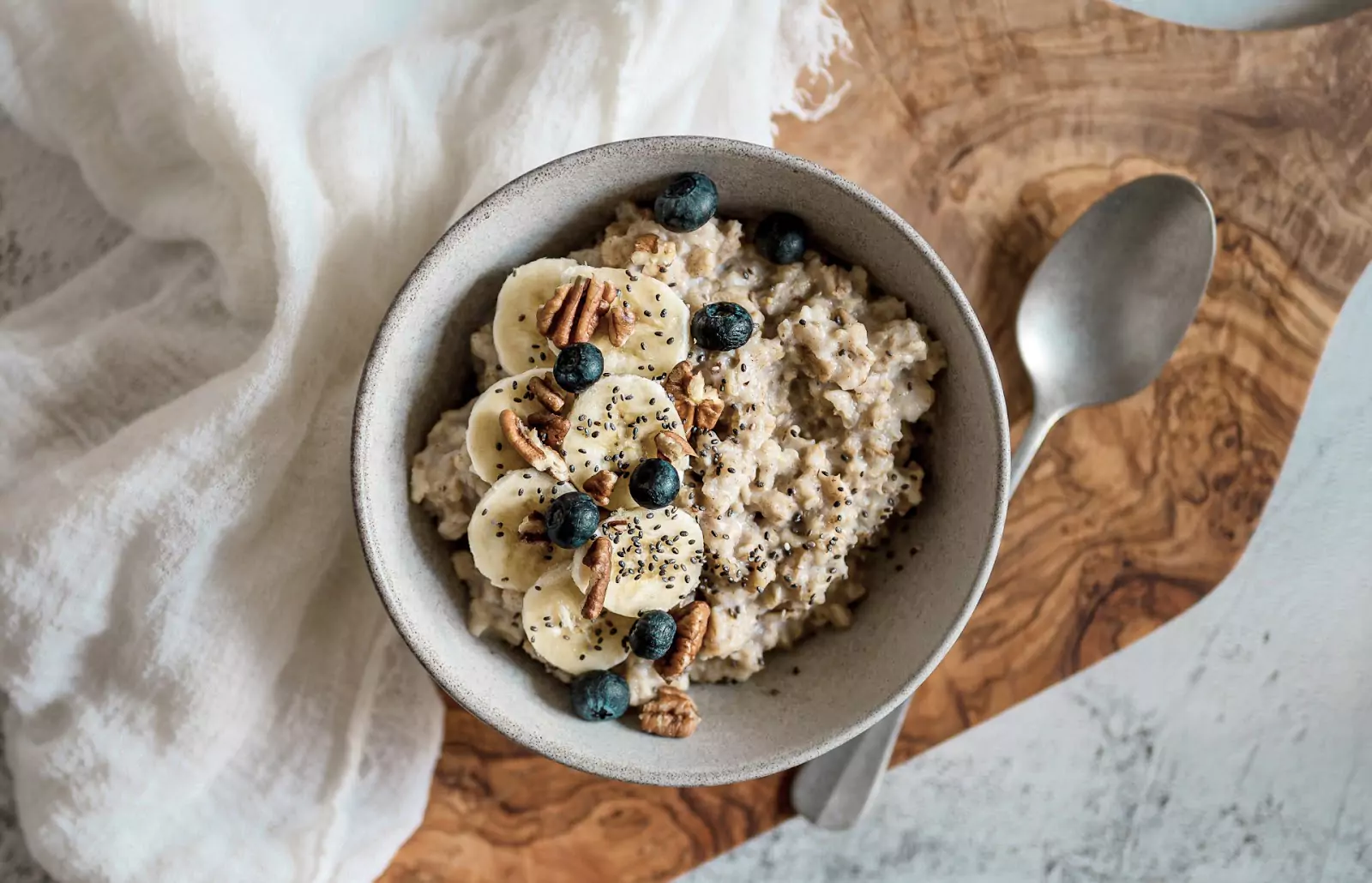 a bowl of porridge with banana, nuts and berries 