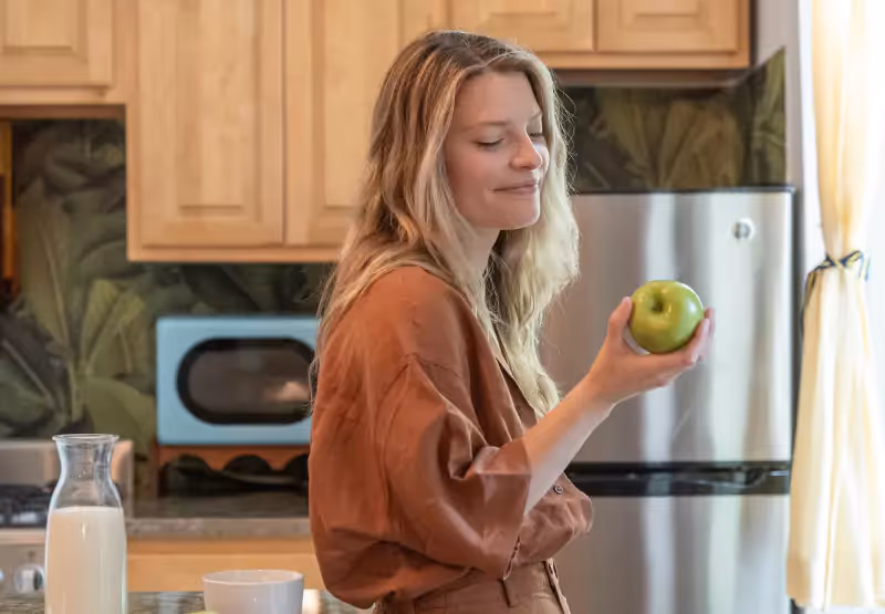 Woman holding an apple in her kitchen