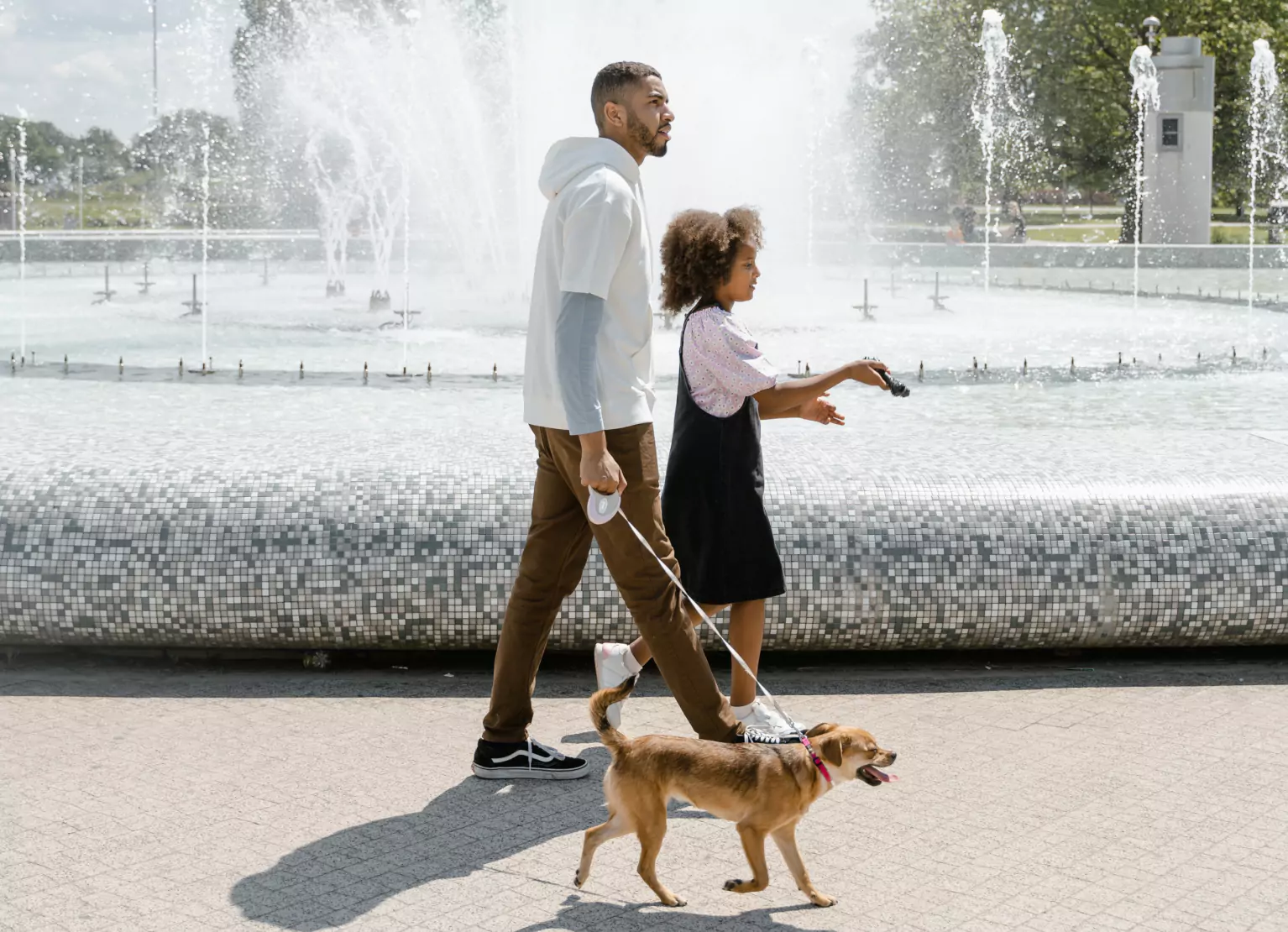 an adult and a kid walking the dog