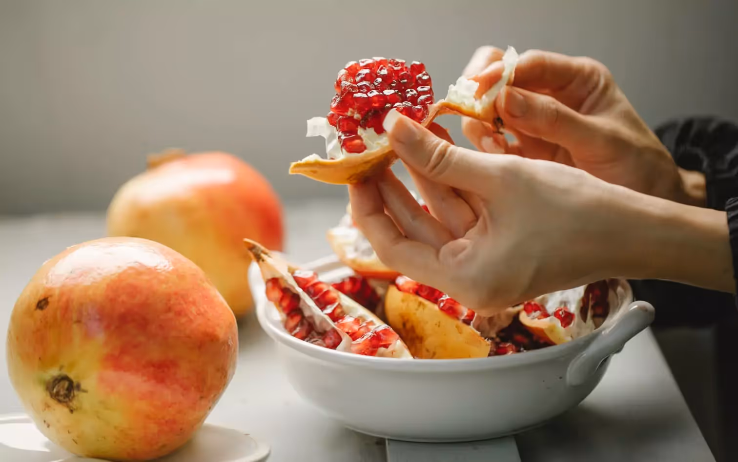 A woman's hands peeling pomegranate