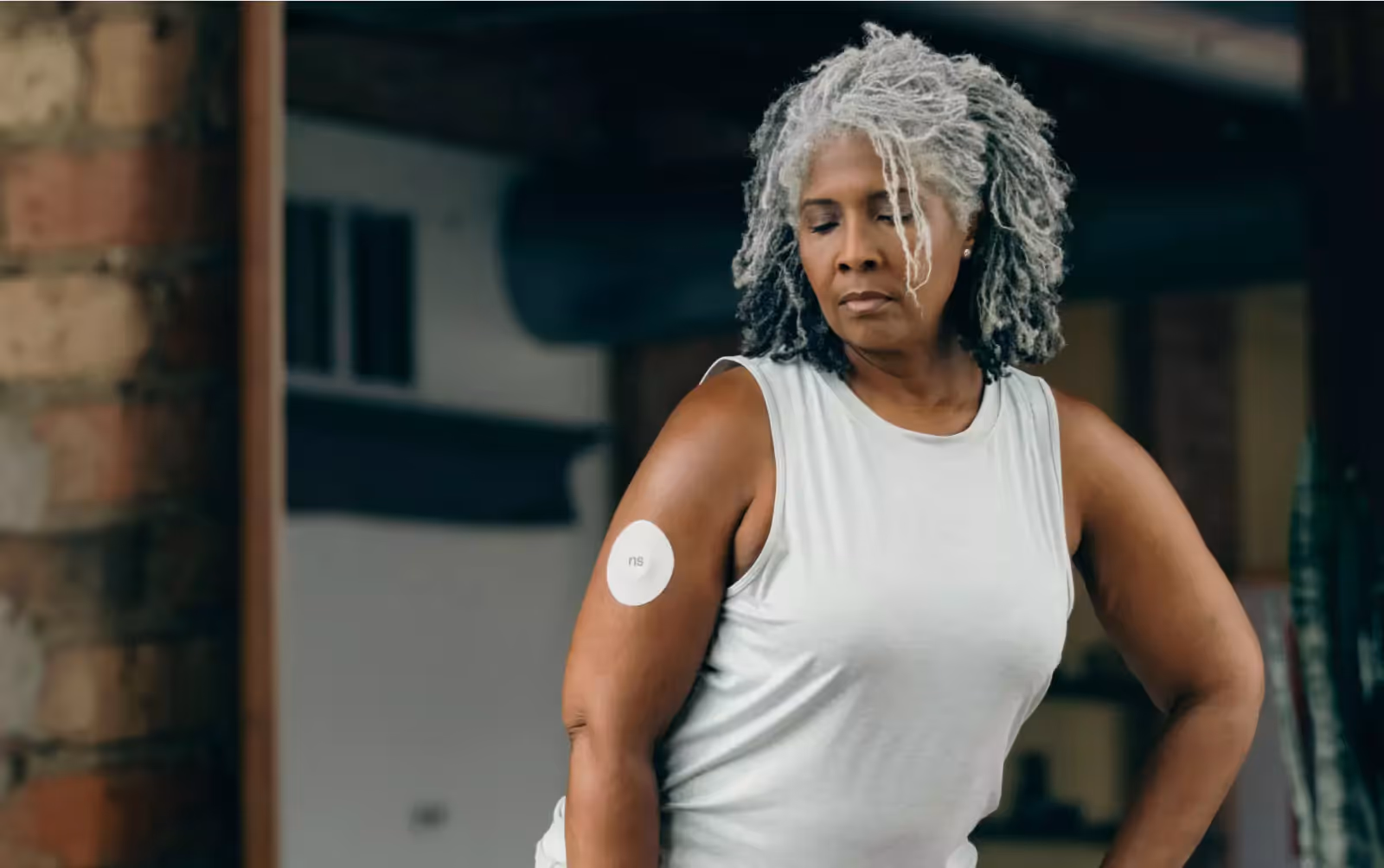 a person wearing Nutrisense CGM and standing