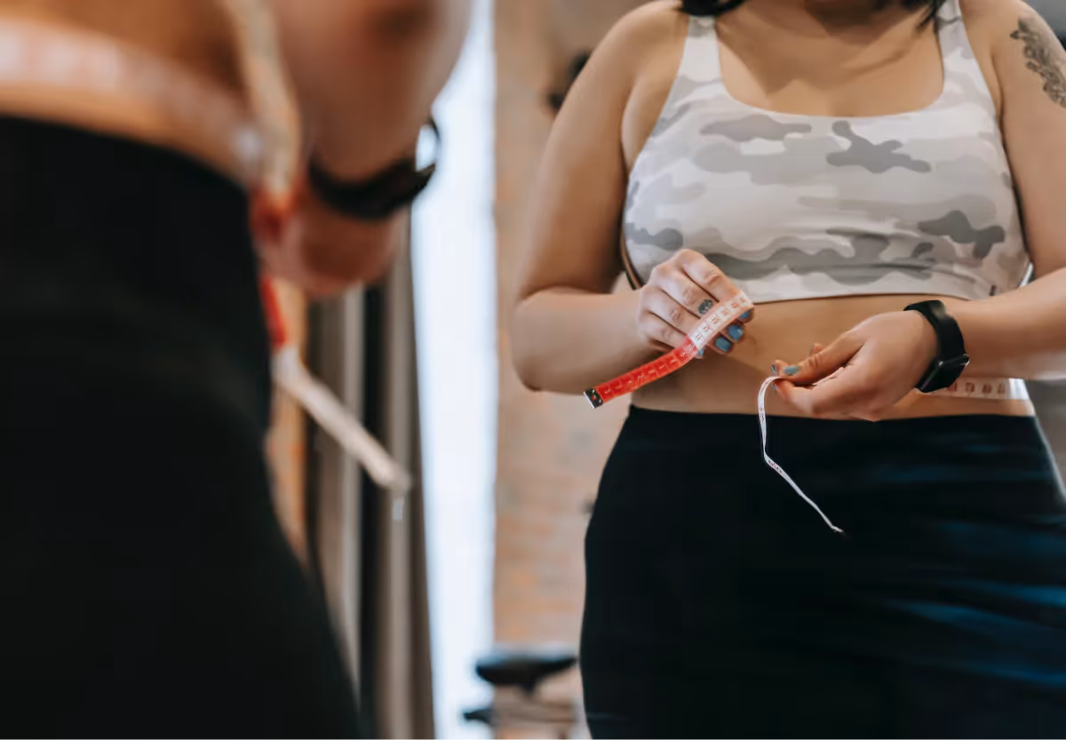 a woman measuring her waist