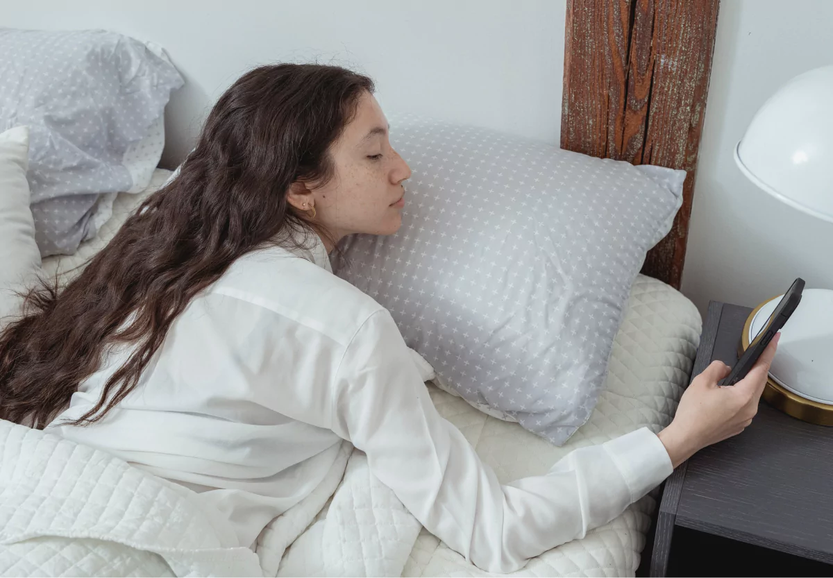 a girl looking at her phone in bed