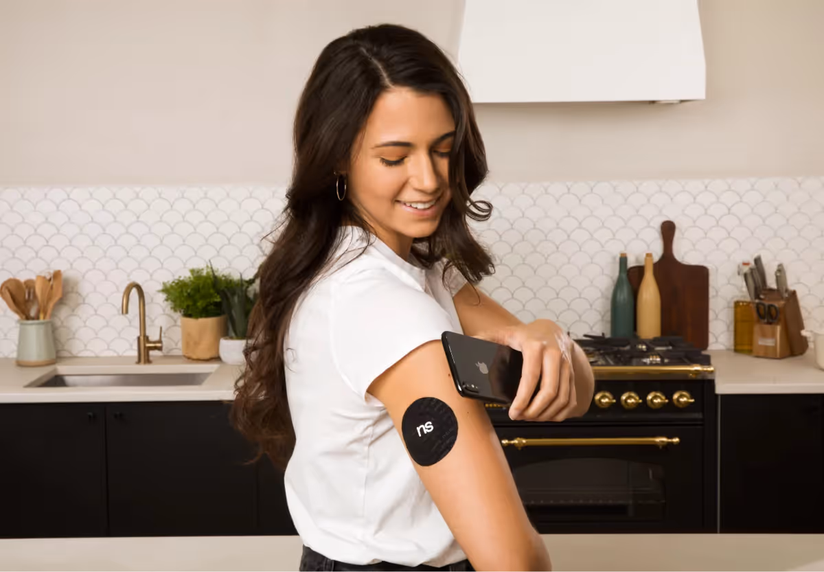 a woman scanning her continuous glucose monitor