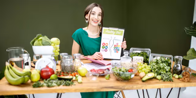 a dietitian sitting at a table full of veggies and fruits 