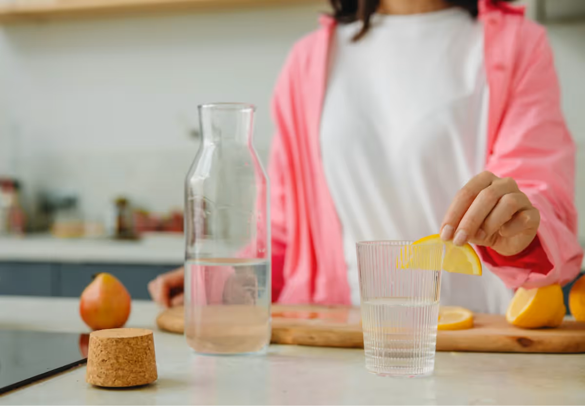 someone adding lemon to their water