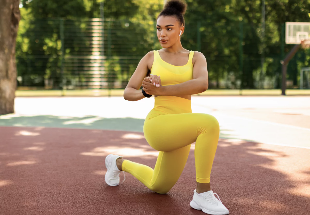 a woman in yellow doing a curtsy lunge