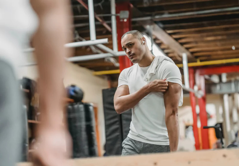 a man looking at his biceps in the gym