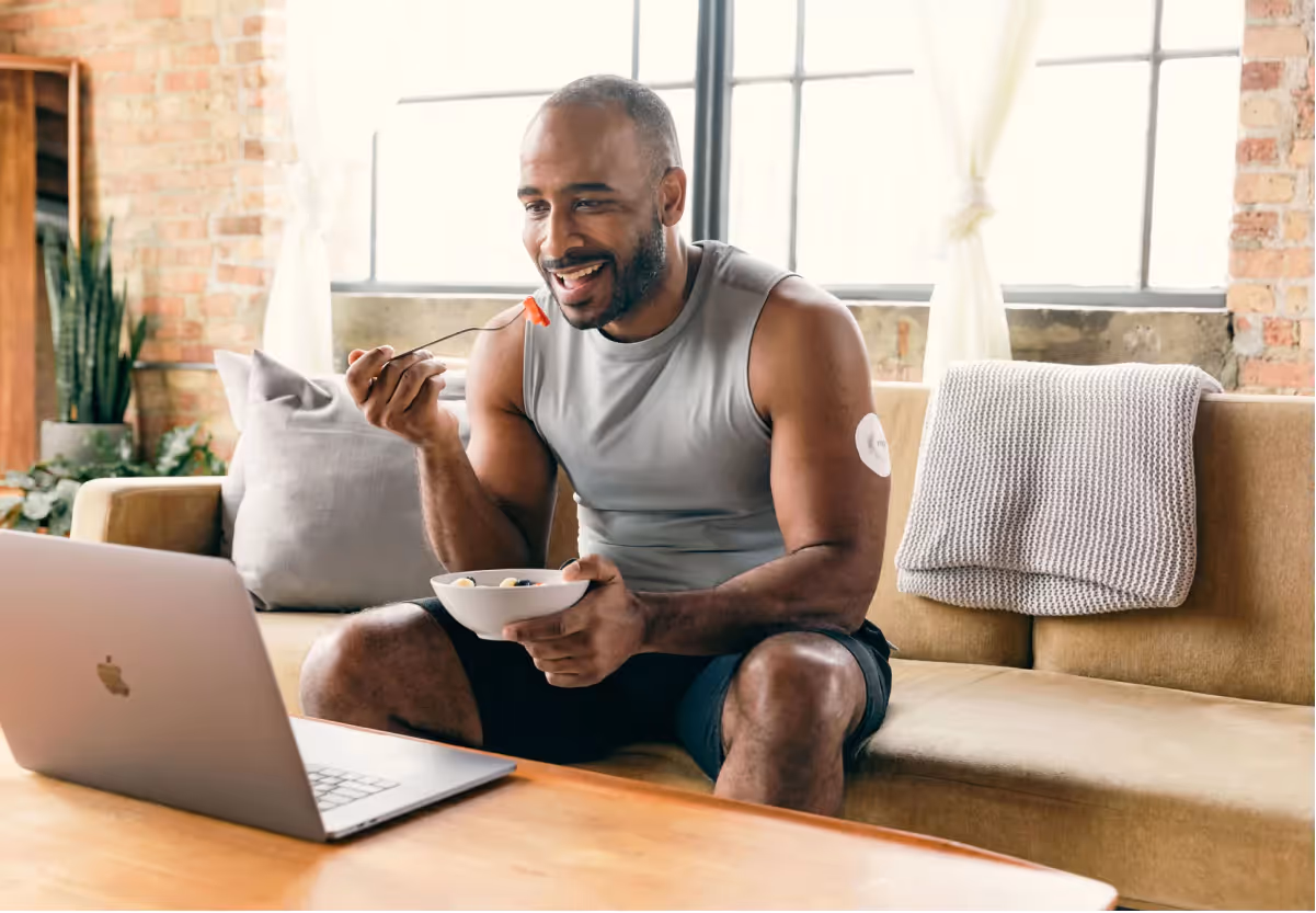 someone wearing a CGM and eating fruit 
