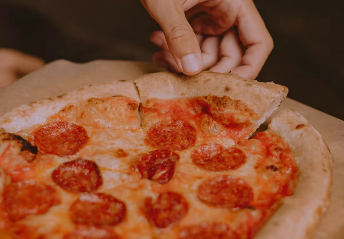 someone grabbing a slice of pizza