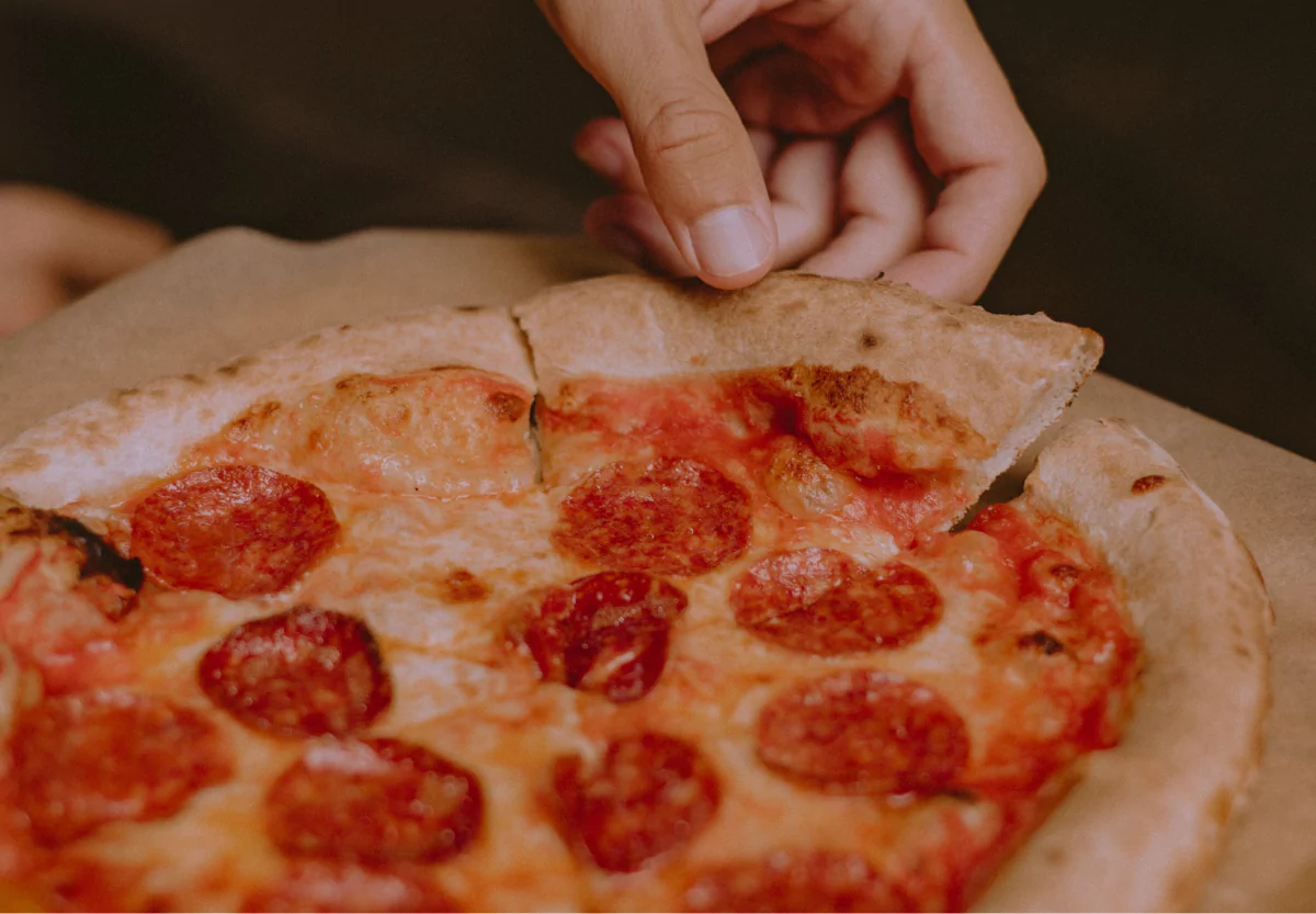 someone grabbing a slice of pizza