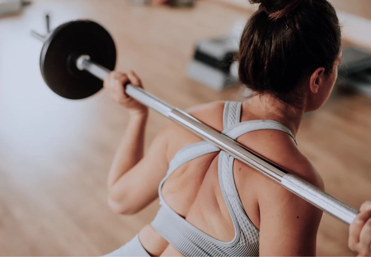a woman doing a barbell squat