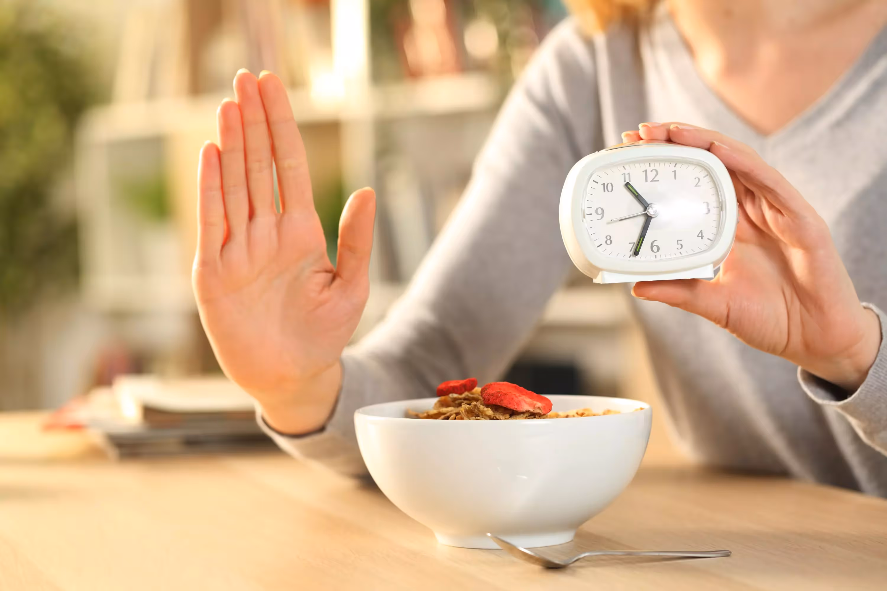 a person showing a stop sign with one hand and holding a clock with another