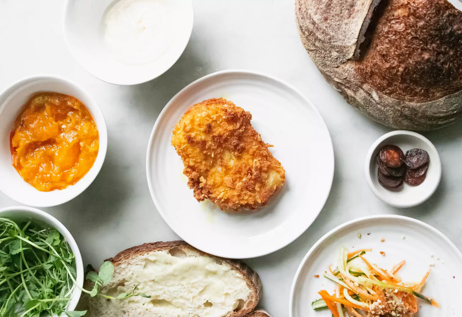 a spread of chicken, bread and other foods