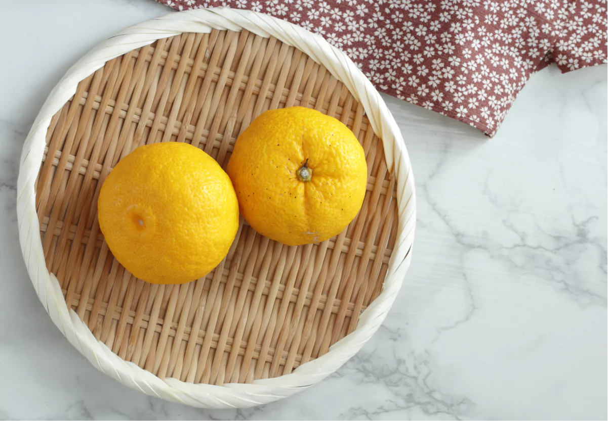 a basket with two yuzu fruit on a counter
