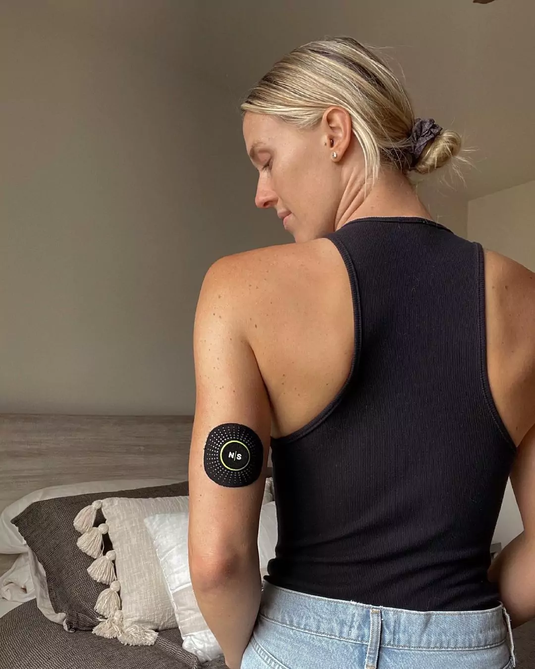 a person sitting, wearing a CGM sensor
