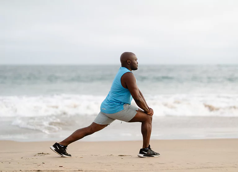 a man stretching on the beach