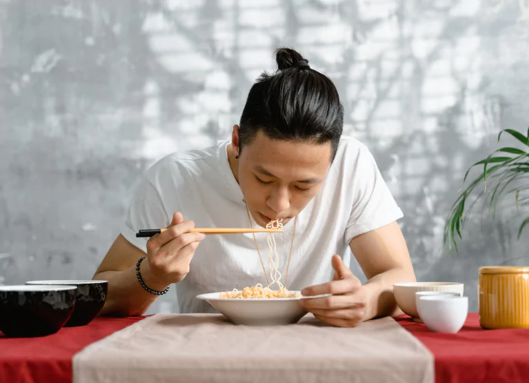 a man eating noodles