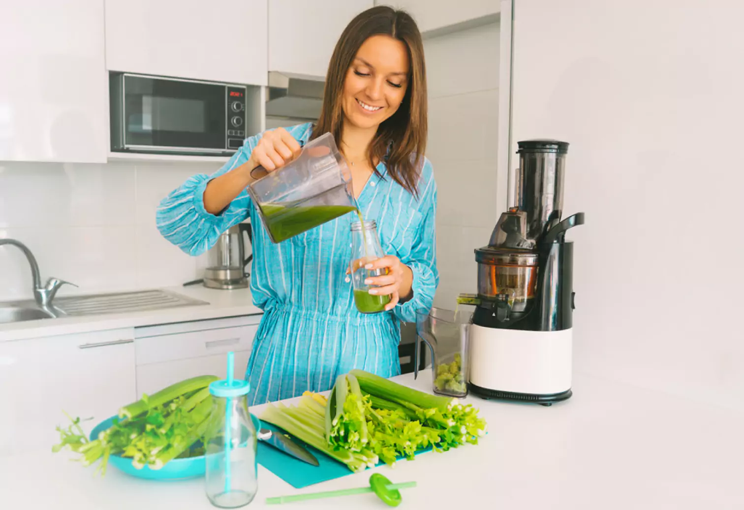 a lady pouring celery juice