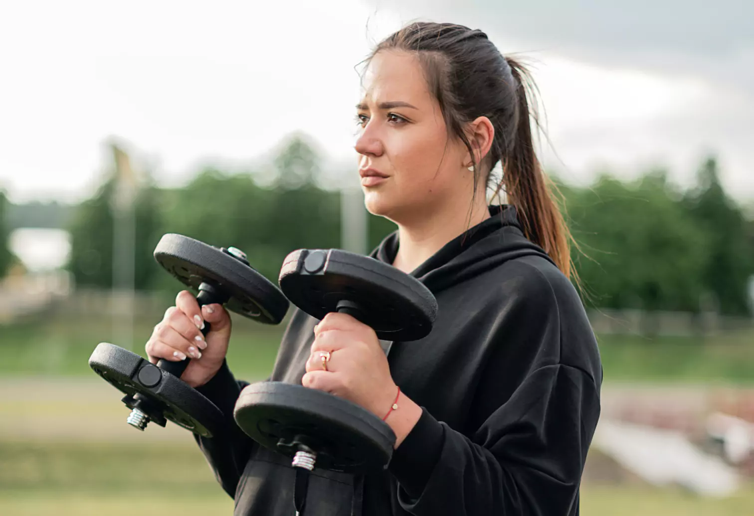 a person holding dumbbells outdoors 