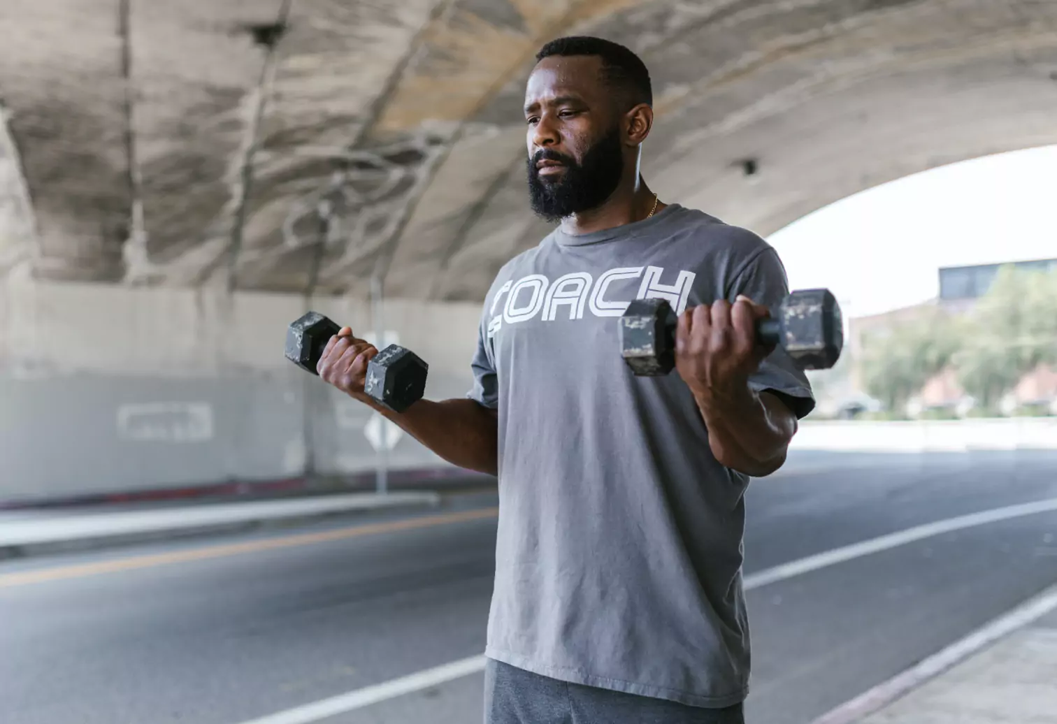 a person holding dumbbells outdoors 