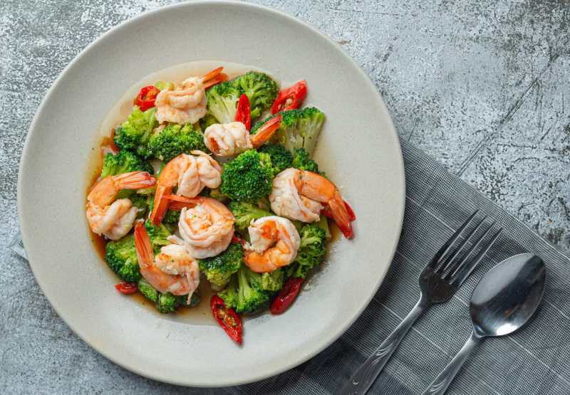 a plate of shrimp and broccoli