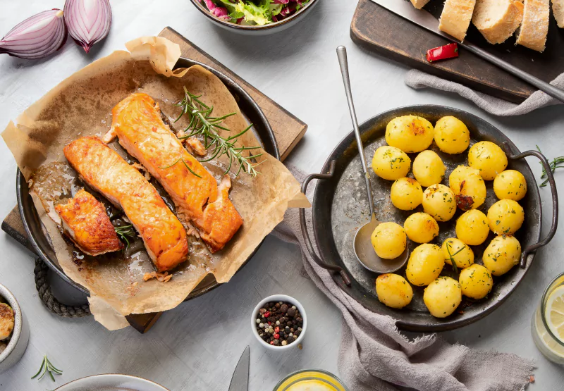 a plate of baked salmon and potatoes