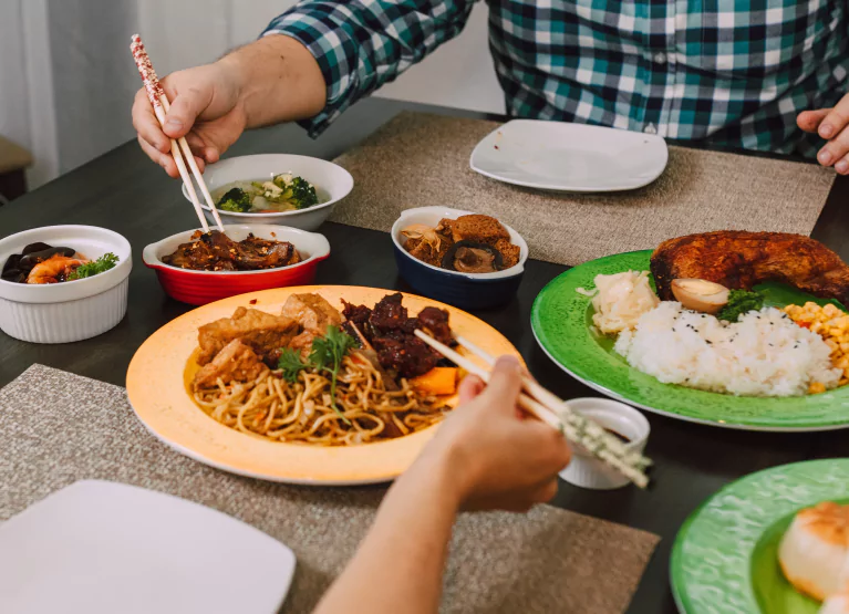 plates of food being eaten with chopsticks
