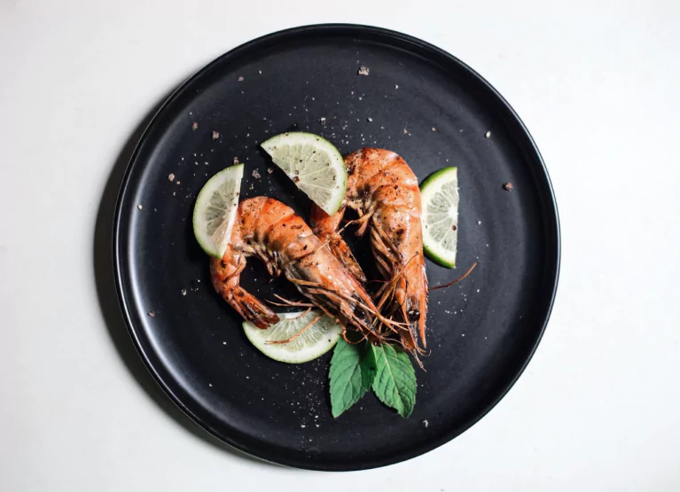 a plate with two large shrimps and lemon