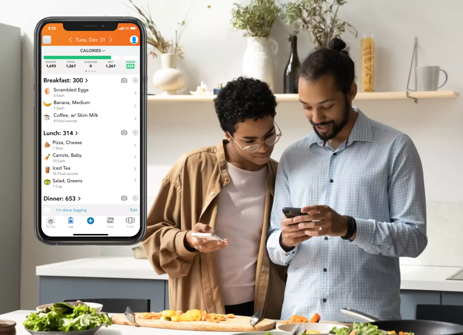Two people tracking calories while cooking with the Lose It! app open on a phone on the left