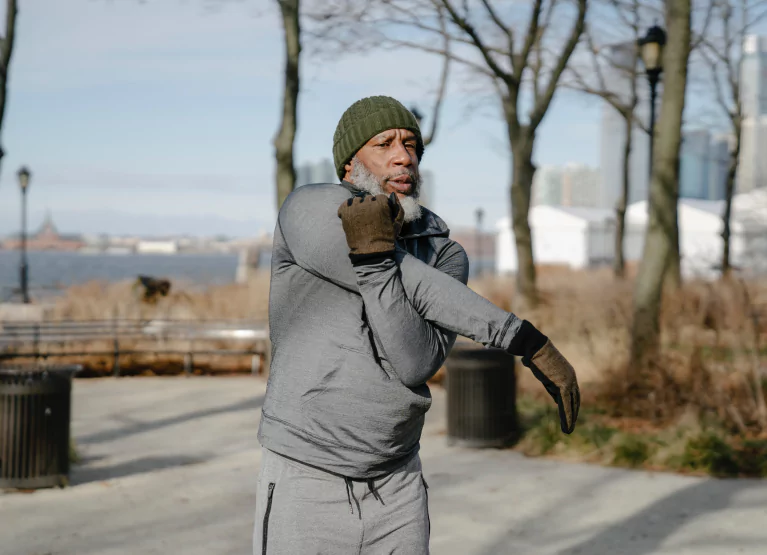 a man stretching his arm in the park